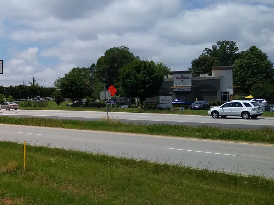 Retail building and parked cars beside US 521 in Indian Land, SC, with an orange road-work sign in the median